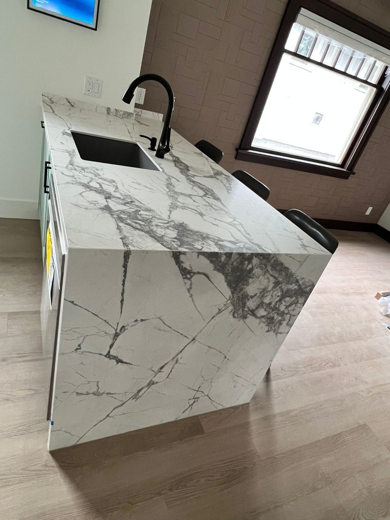 Quartz waterfall-edge countertop with integrated sink in a Calgary kitchen